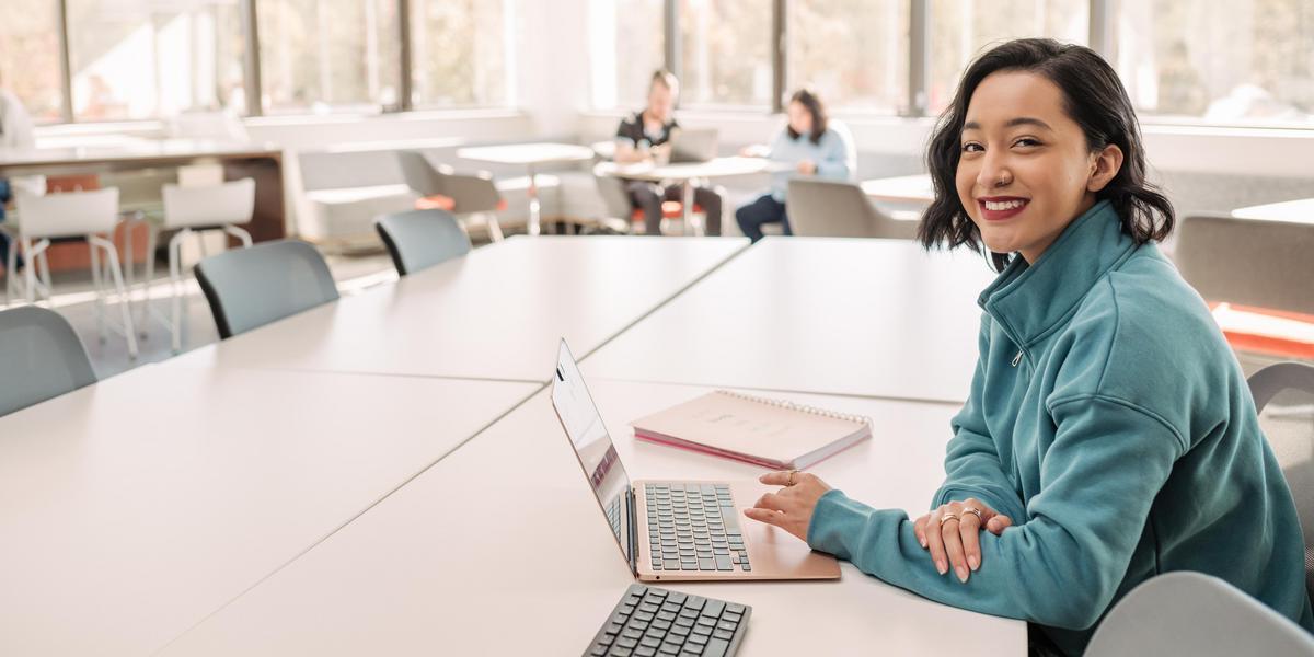 Student smiling for camera while in conference room.